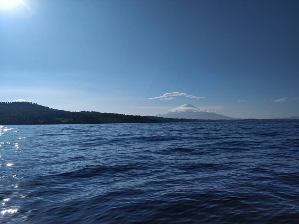 Bunaken and in the background Manado Tua. A clear day with a beautiful blue sky.
